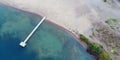 Sandy beach with long wooden pier from above Royalty Free Stock Photo