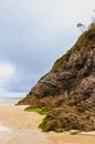 Sandy beach with a majestic rock side. Royalty Free Stock Photo
