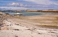 Sandy beach, a pier on the fjord, moored boat Royalty Free Stock Photo