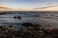 Sandy beach, with rocky outcroppings at the shoreline at sunset in Franzkraal, South Africa