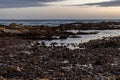 Sandy beach, with rocky outcroppings at the shoreline at sunset in Franzkraal, South Africa