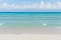 Sandy beach with rolling calm wave of ocean on sunny day on background white clouds in blue sky Royalty Free Stock Photo