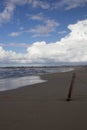 Sandy beach with rough sea and clouds Royalty Free Stock Photo