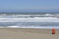 sandy beach, with the sea in the background and an orange lifeguard