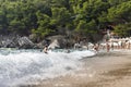 Sandy beach with spalshing waves and people swimming and enjoying summer vibes Royalty Free Stock Photo