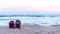 Sandy beach summer holiday vacation background with a pair of flip-flop sandals on hot sunny day on sea or ocean sand Royalty Free Stock Photo