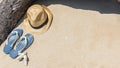 Sandy beach summer holiday vacation with hat and flip-flop sandals on hot sunny day on sea or ocean sand background Royalty Free Stock Photo