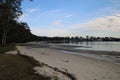 Sandy Beach at Tanilba Bay with coastal forest growing down to the water\'s edge Royalty Free Stock Photo