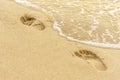 Human footprints in the sand are flooded by a sea wave Royalty Free Stock Photo