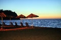 sandy beach with umbrellas and sunbeds in the evening on the island of Lesbos Royalty Free Stock Photo