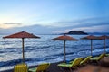 sandy beach with umbrellas and sunbeds in the evening on the island of Lesbos Royalty Free Stock Photo