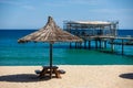 Sandy beach view with a gazebo with a boardwalk and a blue sky background