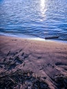 Sandy beach and water at Sundown over the riverside of the river Rhein in Cologne with sky, clouds and bridge Royalty Free Stock Photo