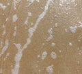 Sandy beach wet surface, top view. Sea tide waves, natural sand and water texture. Smooth sand background. Royalty Free Stock Photo