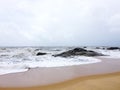 The sandy beaches of Kundapura with rocks and foamy waves