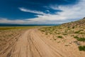 Sandy bumpy road along the shore of the lake. Summer nature view Royalty Free Stock Photo