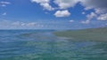 The sandy cape is washed by the waves of the transparent aquamarine ocean