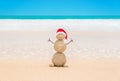 Sandy Christmas Snowman in red Santa hat at beach sand against o Royalty Free Stock Photo