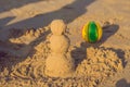 Sandy christmas snowman in red santa hat and sunglasses at sunny beach. Holiday concept for New Years Cards Royalty Free Stock Photo