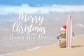 Sandy Christmas Snowman is standing on beautiful beach with a surf board Royalty Free Stock Photo