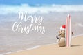 Sandy Christmas Snowman is standing on beautiful beach with a surf board Royalty Free Stock Photo