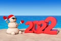 Sandy Christmas Snowman at Sunny Beach with 2022 New Year Sign. 3d Rendering