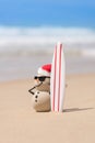 Sandy Christmas Snowman with a surfboard Royalty Free Stock Photo