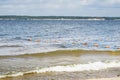 Sandy city beach with small waves and buoys. waves of the river running onto the shore