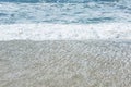 Sandy coast of the turquoise sea. Surging waves, sunny windy day. Space for text Royalty Free Stock Photo