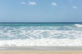 Sandy coast of the turquoise sea. Surging waves, sunny windy day. Space for text Royalty Free Stock Photo