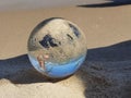 Sandy crystal sphere reflecting the sky on the sand. Beach vacation Royalty Free Stock Photo