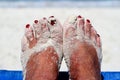 Sandy feet with painted toe nails on the beach Royalty Free Stock Photo