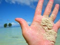 Sandy hand by tropical ocean Royalty Free Stock Photo