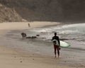 Sandy ocean beach surfer walking