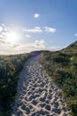 Sandy path winding up a hill, leading to a beautiful vista in Nationalpark Thy, Denmark.