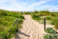 A sandy pathway delimited by wooden posts on a sand dune covered with wild grasses Royalty Free Stock Photo