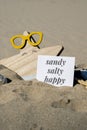 SANDY SALTY HAPPY text on paper greeting card on background of funny starfish in glasses summer vacation decor. Beach Royalty Free Stock Photo