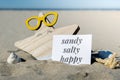 SANDY SALTY HAPPY text on paper greeting card on background of funny starfish in glasses summer vacation decor. Beach Royalty Free Stock Photo