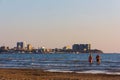 Sandy sea beach on the black sea with the last vacationers overlooking the city of Anapa in the summer evening