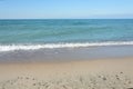 Sandy seashore with small stones. Surf and wave with white foam close-up. Travel concept, sea vacation Royalty Free Stock Photo