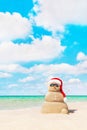 Sandy snowman in santa hat at beach. Christmas concept Royalty Free Stock Photo