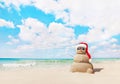 Sandy snowman in santa hat on sea beach. New Years and Christmas Royalty Free Stock Photo