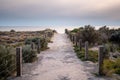 Sandy walkway towards the sea on a sunny day.