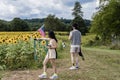 Stylish couple point to sunflowers at the Sussex County Sunflower Maze