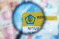 NPWP Card or Indonesia Taxpayer Registration Number Card under magnifying glass with selective focus