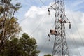 Workers install cable on electric tower.