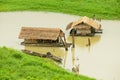 Traditional bamboo floating houses with straw covered roofs at Song Kalia river in Sangkhlaburi, Thailand.