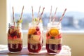 sangria-filled mason jars with paper straws by seashore