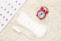 Sanitary menstruation pad for woman menstrual period. Red clock