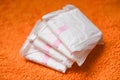 Sanitary napkin or feminine sanitary pad on a orange knitted blanket - Female hygiene means women Period Product absorbent sheets